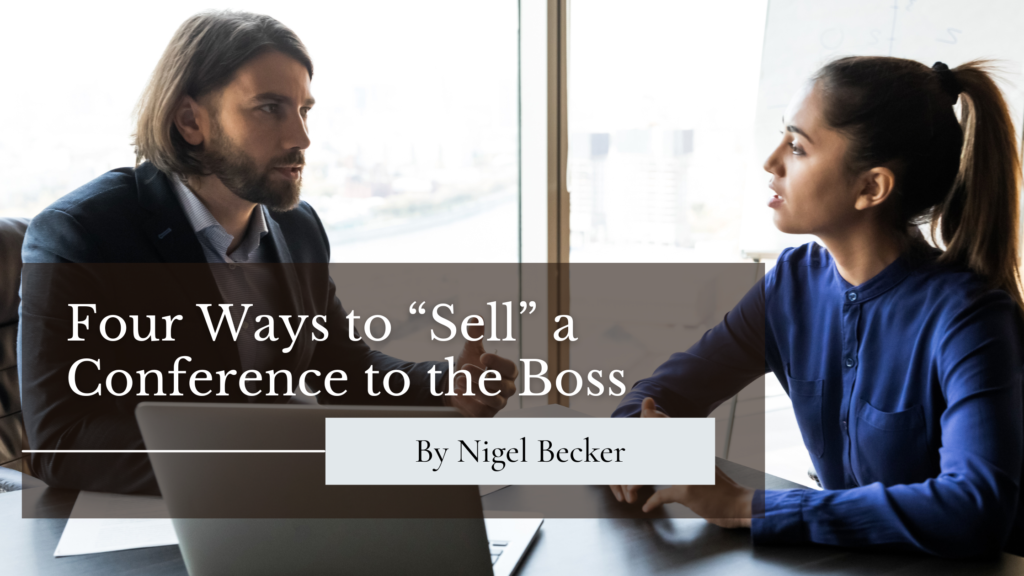 An employee (left) sitting at a table asking his boss (right) for permission to attend a conference